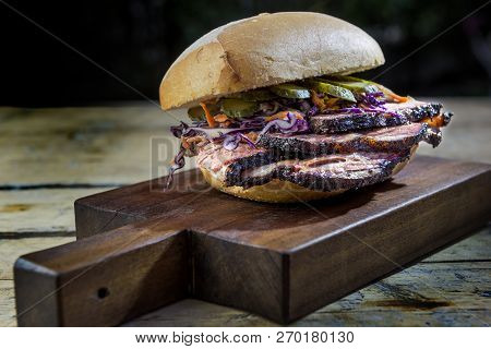 Brisket Sandwich With Cucumber And Coleslow On Cutting Board