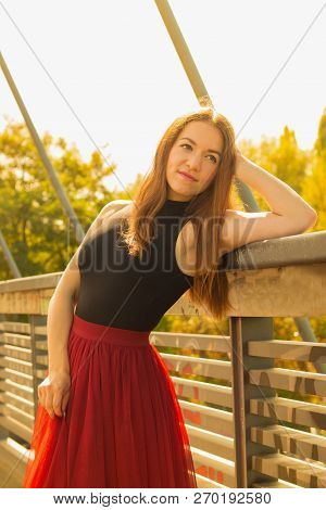 Young Slim Beautiful Woman With Long Brown Hair Smiling Outdoors In Black Shirt And Terracotta (red 