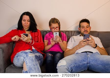 Family Busy With Mobile Phones/family Sitting On Couch And They Busy With Mobile Phones.
