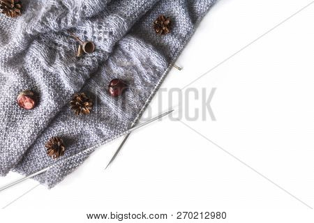 Diagonal Grey Knitwork On Needles With Chestnuts, Pinecones On A White Background, Place For Text. A