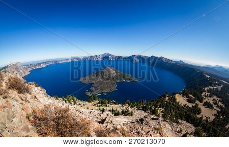 Photograph Of Mount Thielsen On A Sunny Clear Day With Vivid Blue Skies And Green Forest