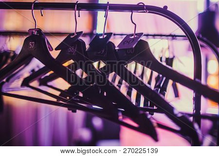 Stock Of Empty Clothes Hanger In Wardrobe, Wooden Coat Hangers Hanging On A Cloth Rail Rack In Close