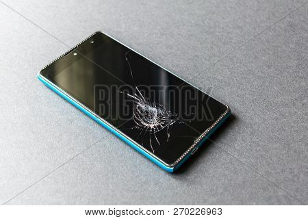 Smartphone With A Broken Screen On A Dark Background. Close Up