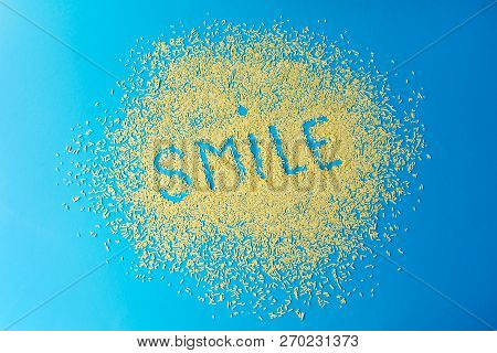 Text Smile On A Blue Background. Confectionery Sprinkles. Yellow Sugar Grains On A Blue Color. Stock