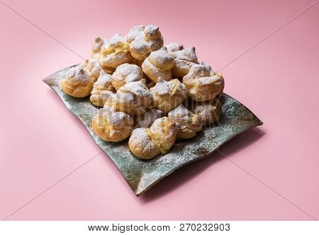 Homemade Profiteroles Served On A Plate With A Cup Of Tea On A Pink Background. Flat Lay. Stock Imag