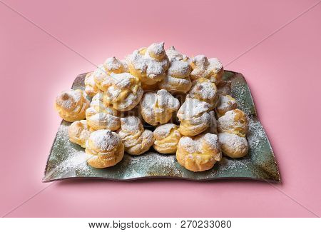 Cakes Profiteroles Sprinkled With Powdered Sugar On A Pink Background. Homemade Eclairs. Stock Image