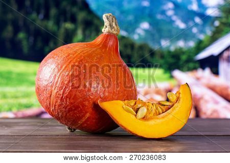 Group Of One Whole One Slice Of Fresh Red Kuri Pumpkin Hokkaido Variety With Country Nature In Backg