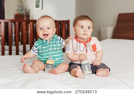 Group Portrait Of Two White Caucasian Cute Adorable Funny Baby Boys Sitting Together On Bed Socializ