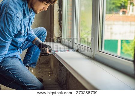 Man In A Blue Shirt Does Window Installation