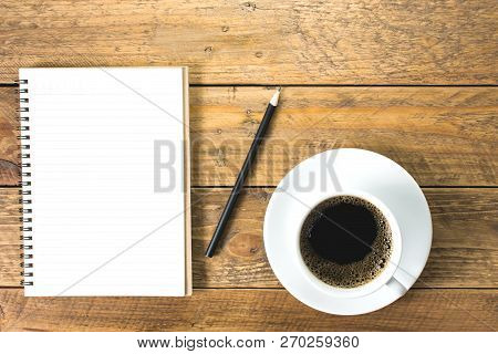 Black Coffee In White Ceramic Cup With Saucer. With Notbook And Pencils For Notes. Placed On Vintage
