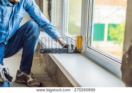 Man In A Blue Shirt Does Window Installation