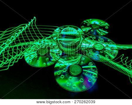 A Combination Of Luminescent Light, Flat Discs, Silver Coins, And Lensball Creates An Abstract Green