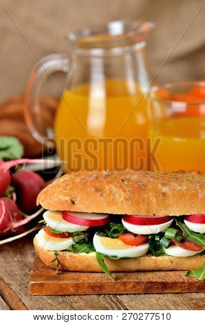 Baguette Sandwich With Egg, Arugula Salad, Tomatoes And Radish