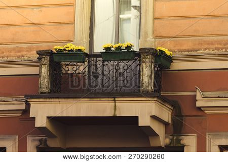 Close Up On An Old  European Balcony With Ellow Flowers.