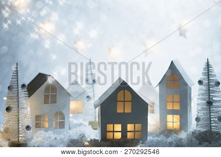 Christmas And New Year Miniature Magical House In The Snow At Night And Bokeh City Lights. Christmas