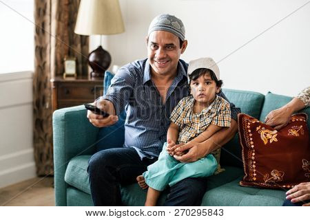Muslim family watching tv at home