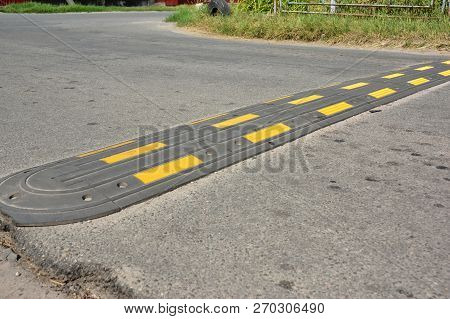 Traffic Safety Speed Bump On An Asphalt Road. Speed Bumps Or Speed Breakers Are Traffic Calming Devi