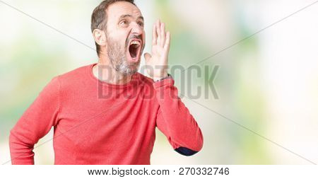 Handsome middle age hoary senior man wearing winter sweater over isolated background shouting and screaming loud to side with hand on mouth. Communication concept.