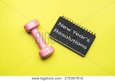 New Year Healthy Goals And Resolutions Concept. New Year's Resolutions Written On Black Notebook Pap