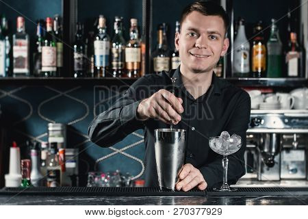 Bartender Making Boulevardier Cocktail Pouring Fluid Into Glass. Bar On A Background