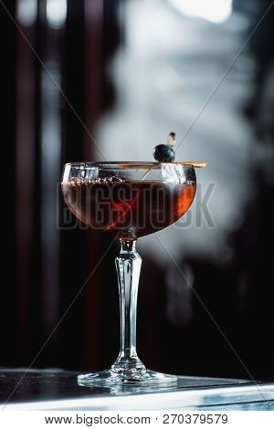 The Boulevardier Cocktail With Orange Chips On Top. On A Bar Desk