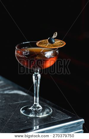 The Boulevardier Cocktail With Orange Chips On Top. On A Bar Desk