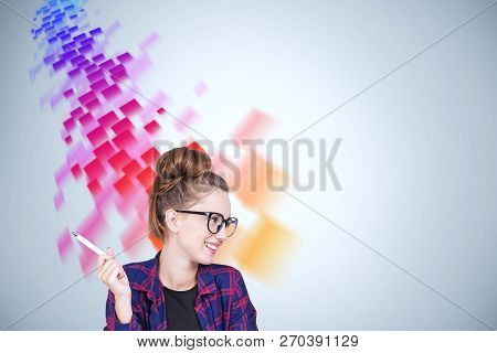 Smiling Geek Girl In Glasses Wearing Checkered Shirt Sitting Near Gray Wall With Red And Purple Flow