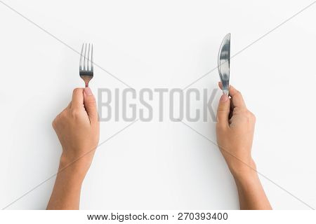 Hungry Woman. Female Hands Holding Fork And Knife On White Background, Top View, Copy Space