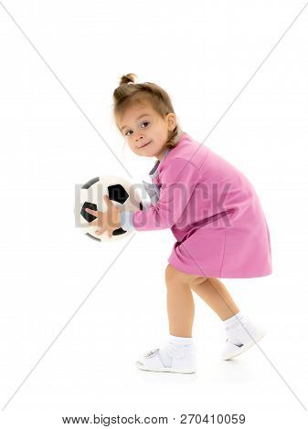 Adorable Little Girl With A Soccer Ball. The Concept Of Childrens Sports, Summer Outdoor Recreation.