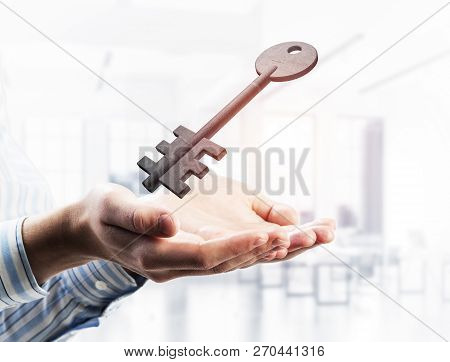 Cropped Image Of Businessman In Suit Keeping Stone Key Symbol In Hands. Mixed Media
