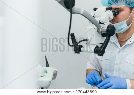 Doctor Used Microscope. Dentist Is Treating Patient In Modern Dental Office. Operation Is Carried Ou