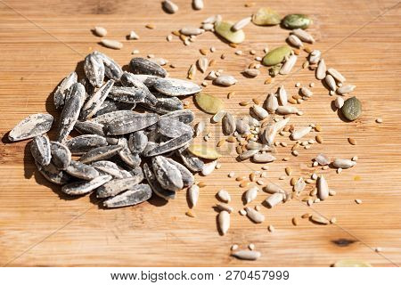 A Closeup Of Sunflower, Sesame And Pumkin Seeds Over A Wooden Table. Healthy Seeds Of Sunflower, Ses
