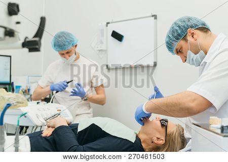 Doctor Used Microscope. Dentist Is Treating Patient In Modern Dental Office. Operation Is Carried Ou