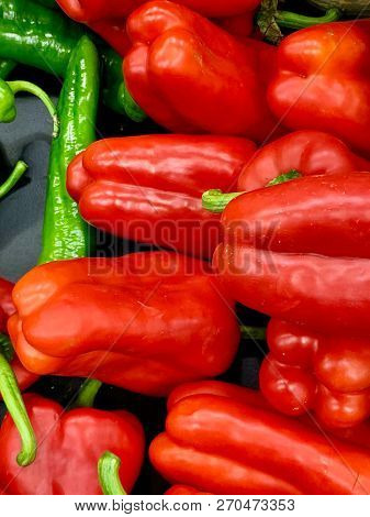 A Close-up Of Fresh Peppers. Most Of Them Are Red Contrasting With The Few Green Ones. Great Vivid C