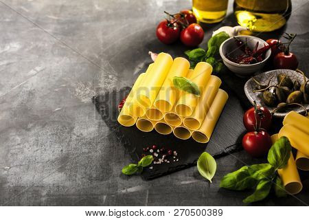 Fresh Raw Homemade Connelloni Pasta On Dark Table.