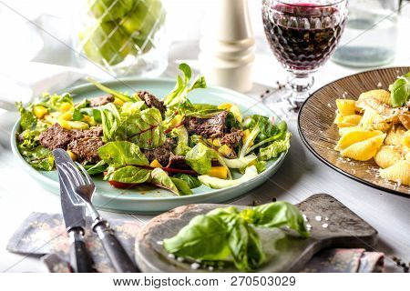 Fresh Salad Plate With Mixed Greens Arugula, Mesclun, Mache On Dark Wooden Background Close Up. Manz
