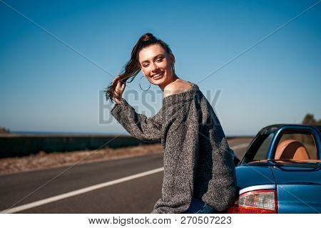 Young Woman With A Tail Standing Near Roofless Car Outdoors
