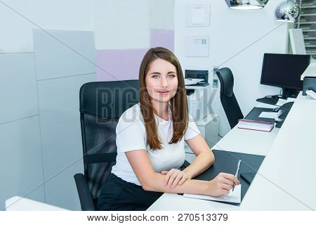 Portrait Of Skilled Administrative Manager Sitting On Her Office Workplace And Making Notes. Satisfi