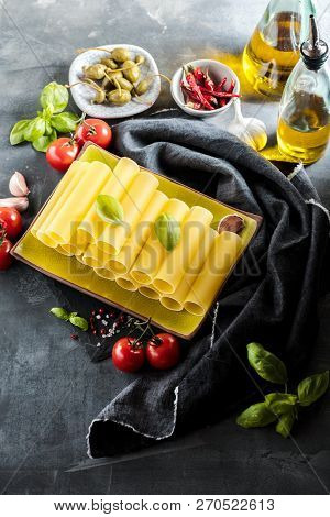 Fresh Raw Homemade Connelloni Pasta On Dark Table.