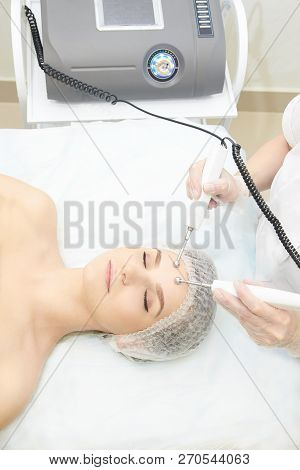 Facial Micro Current Cosmetology Procedure. Beauty Technology Treatment. Woman Face Therapy