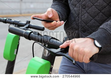 Close Up Image Of A Man On An Electric Scooter Paying Online
