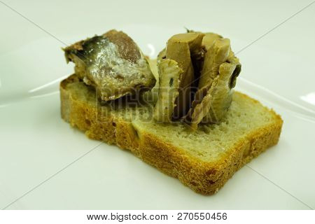 Open Sandwich Made Of Brown Sprouted Bread, Slices Of Fillet Of Pickled Atlantic Herring And Green O