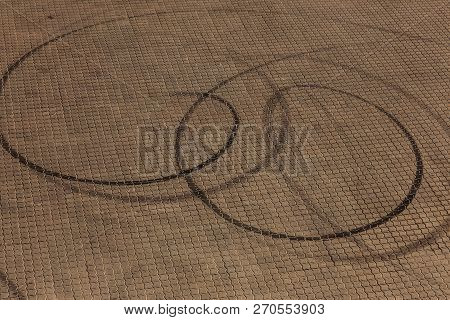 Abstract Transport Background With Pivoting Black Tire Track Over Asphalt Road Surface. Trace Of Dri