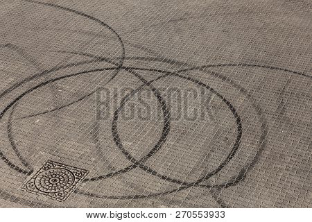 Abstract Transport Background With Pivoting Black Tire Track Over Asphalt Road Surface. Trace Of Dri