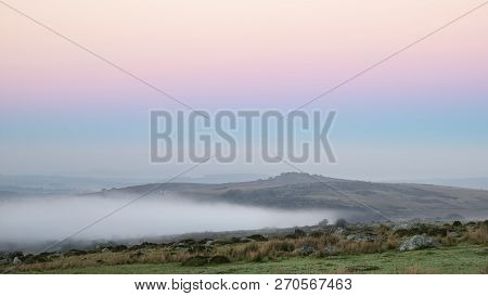 Stunning Foggy Sunrise Landscape Over The Tors In Dartmoor Revealing Peaks Through The Mist