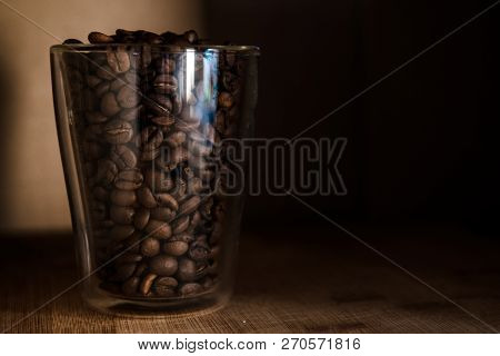 Coffee Beans In Glass Cup On Black Background