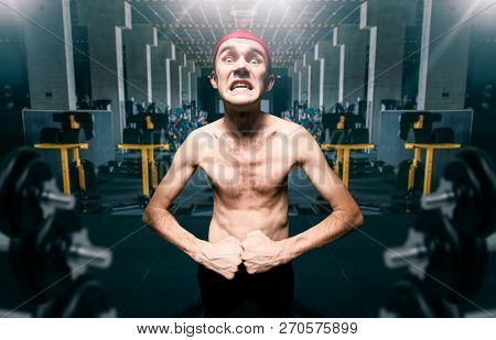 Thin guy poses on workout in gym, dystrophic