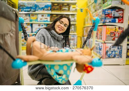 Pregnant woman choosing hanging bed in store