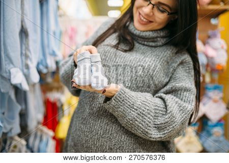 Happy future mother buys childrens clothes