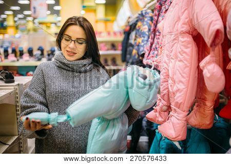 Future mother in the store for newborns, cloth